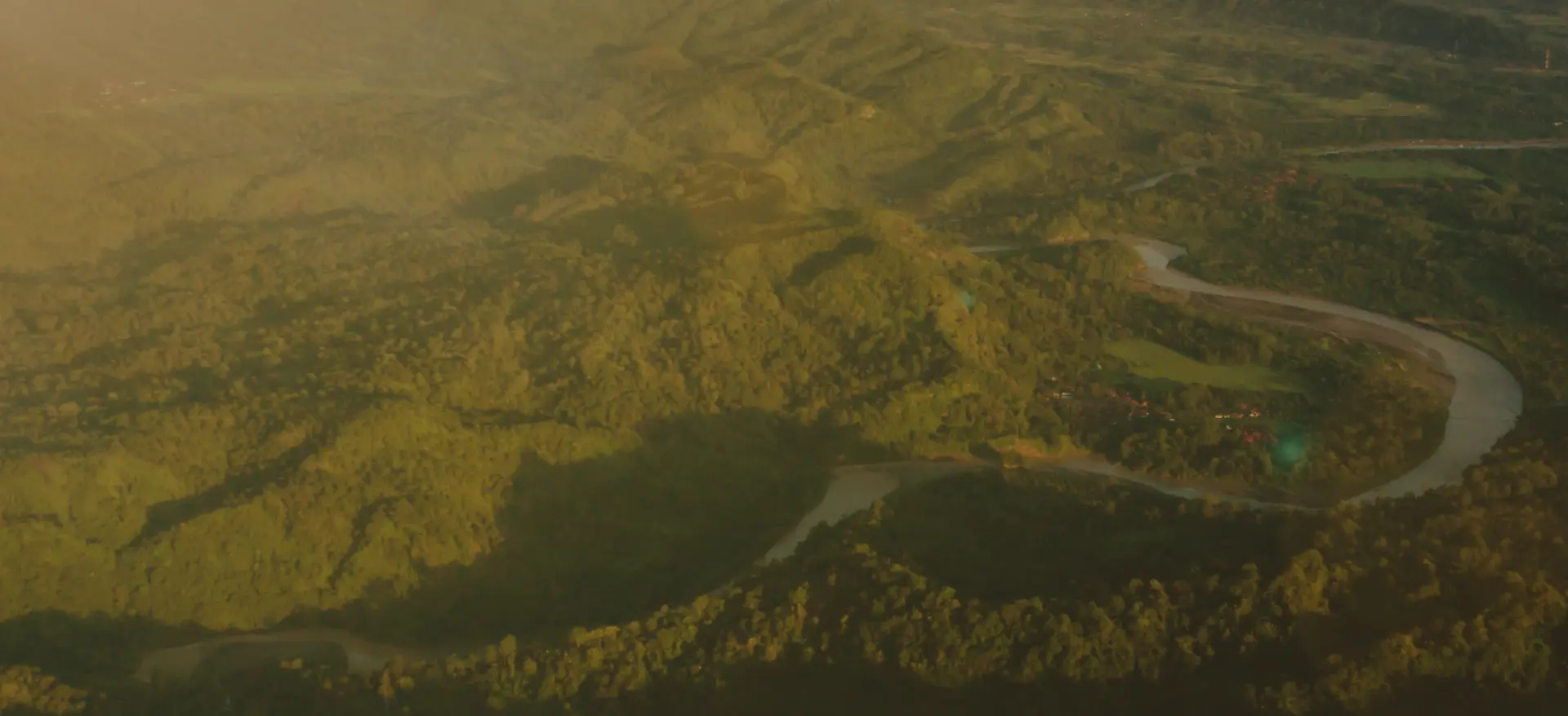 Aerial view of textile factories and farmland along a river in West Java